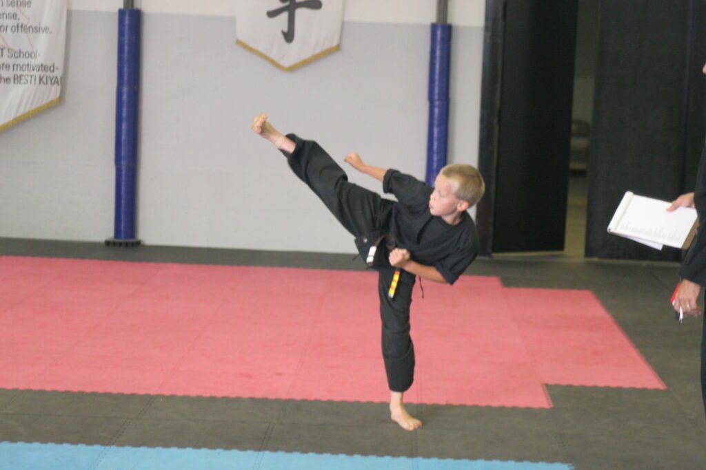 Image of Jake Chappell performing a side kick during a black belt test.